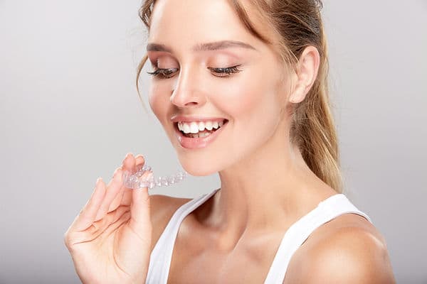 A clear Invisalign aligner held up to the light