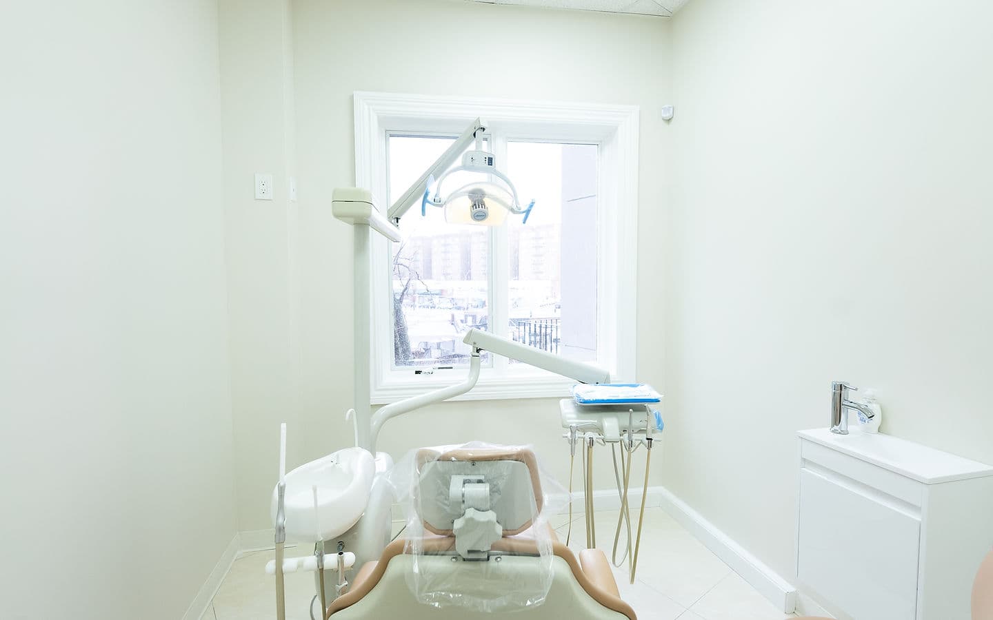 A treatment room at Dream Smile Dental with a dental chair and window light