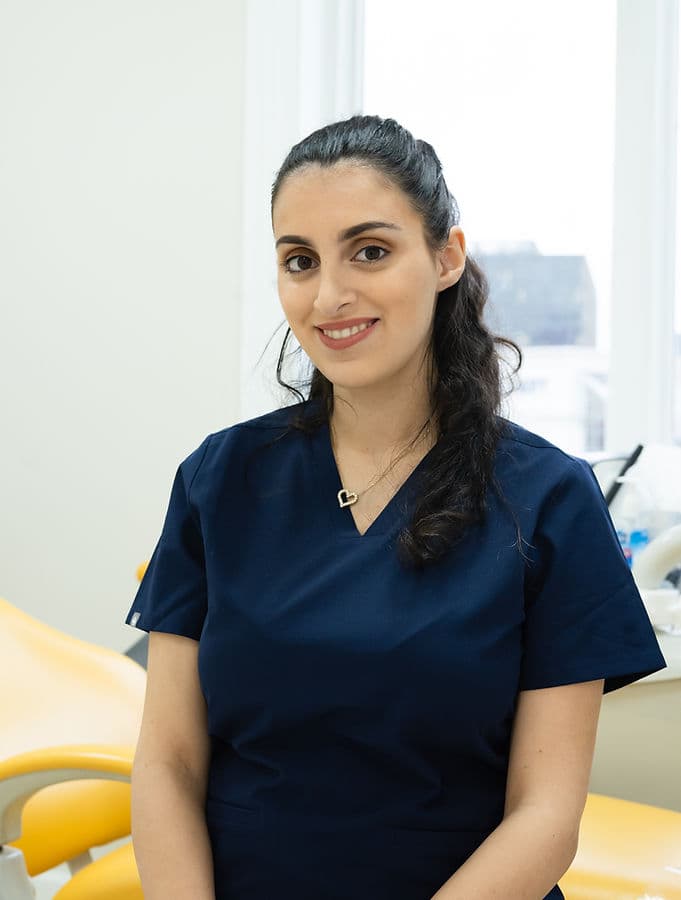 Esther, dental assistant, in navy scrubs in a treatment room